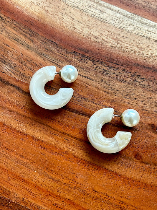 Pair of earrings on a wooden surface

Acrylic hoop earring with pearl accent and 925 sterling silver faux pearl post