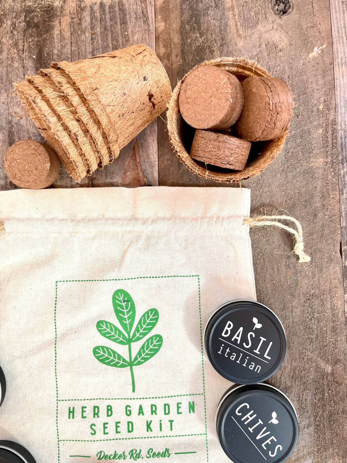 Herb garden seed kit with cork containers and seed packets on a wooden surface