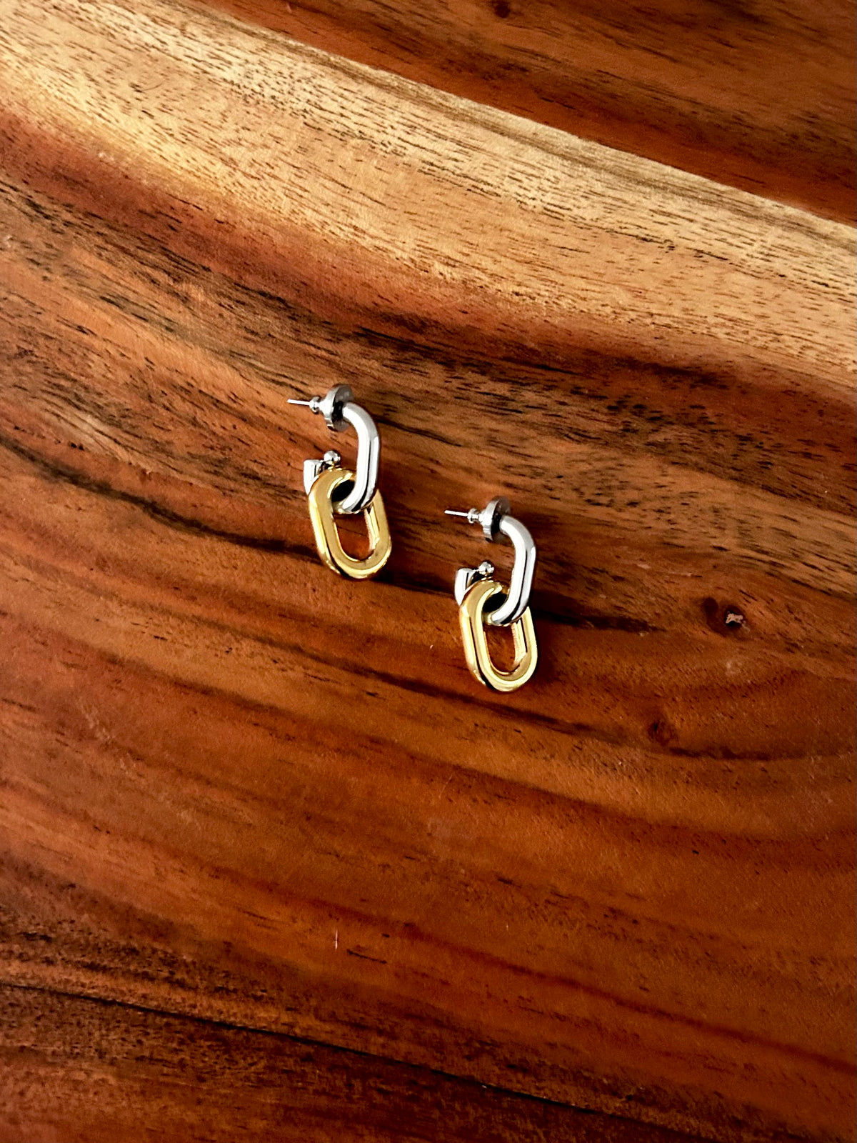 Gold hoop earrings on a wooden surface 18K Gold Plating, Stainless Steel, Sterling Silver Plating&nbsp;

Measurement (L x W inch): 1.26inx0.54in

Lead-free, Nickel-safe

Hypoallergenic

Water Resistant