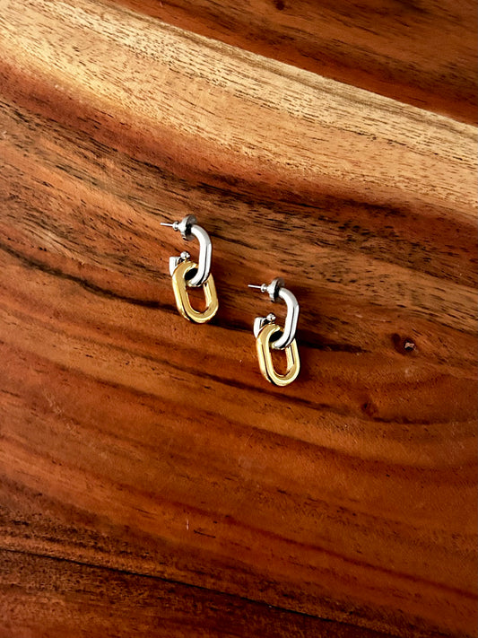 Gold hoop earrings on a wooden surface 18K Gold Plating, Stainless Steel, Sterling Silver Plating&nbsp;

Measurement (L x W inch): 1.26inx0.54in

Lead-free, Nickel-safe

Hypoallergenic

Water Resistant