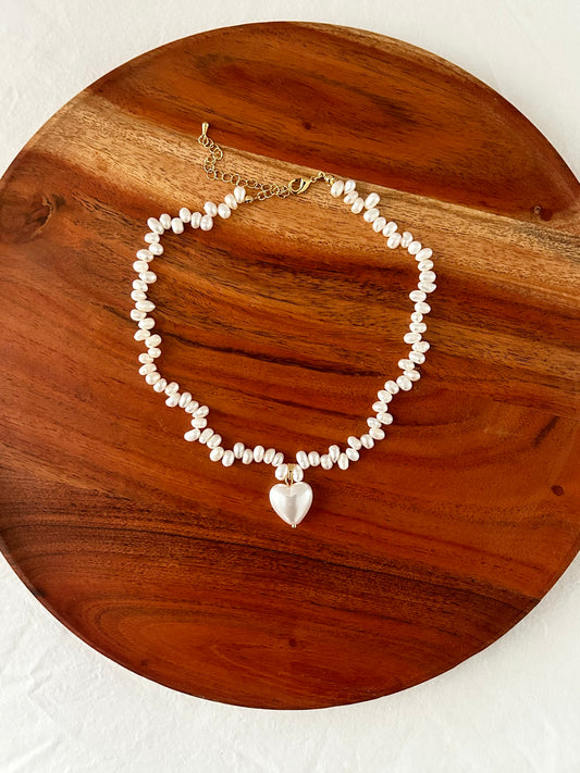 Pearl bracelet with a heart charm on a wooden surface

18K Gold-Plated Brass, Natural Baroque Pearl

Pendant Size (inch): 0.65 x 0.65

Chain Length (inch): 14.5

Extension Length (inch): 3 - Nickel-free, Lead-safe
