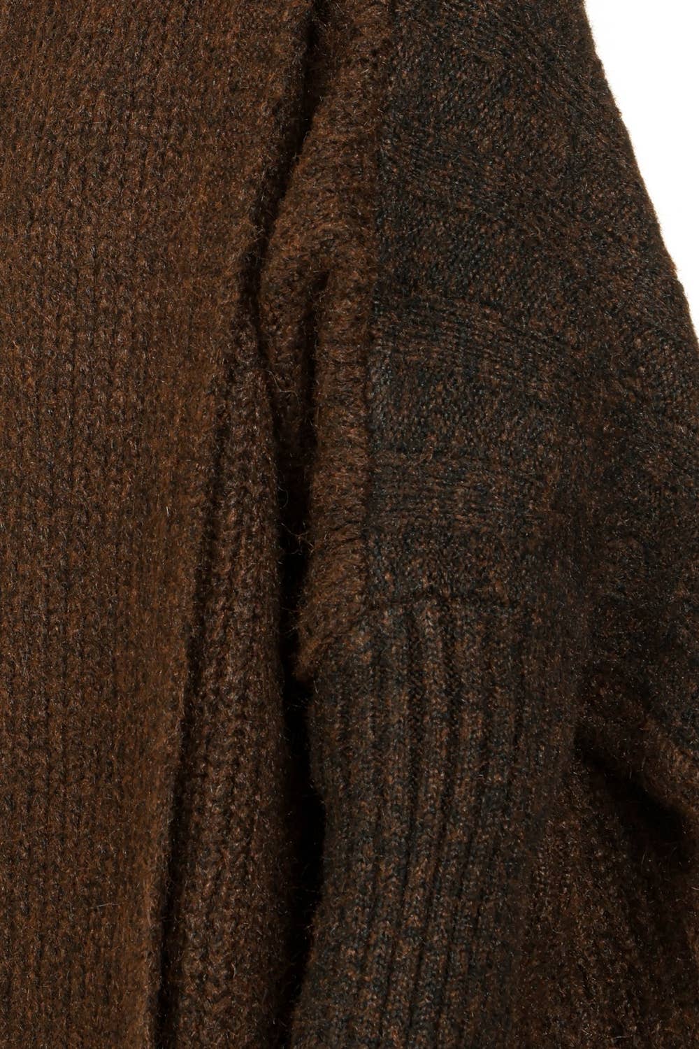 Close-up of a dark brown ribbed knit sweater showing the texture and ribbed sleeve construction.