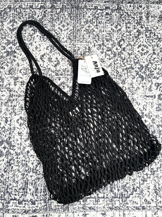 Black mesh bag with a tag on a textured gray background